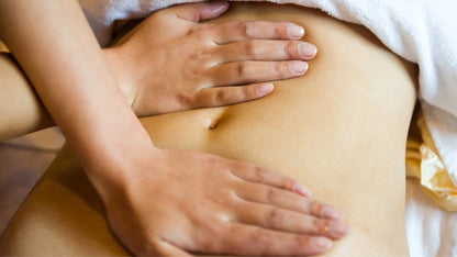 Szene einer Bauchmassage mit zwei Händen.