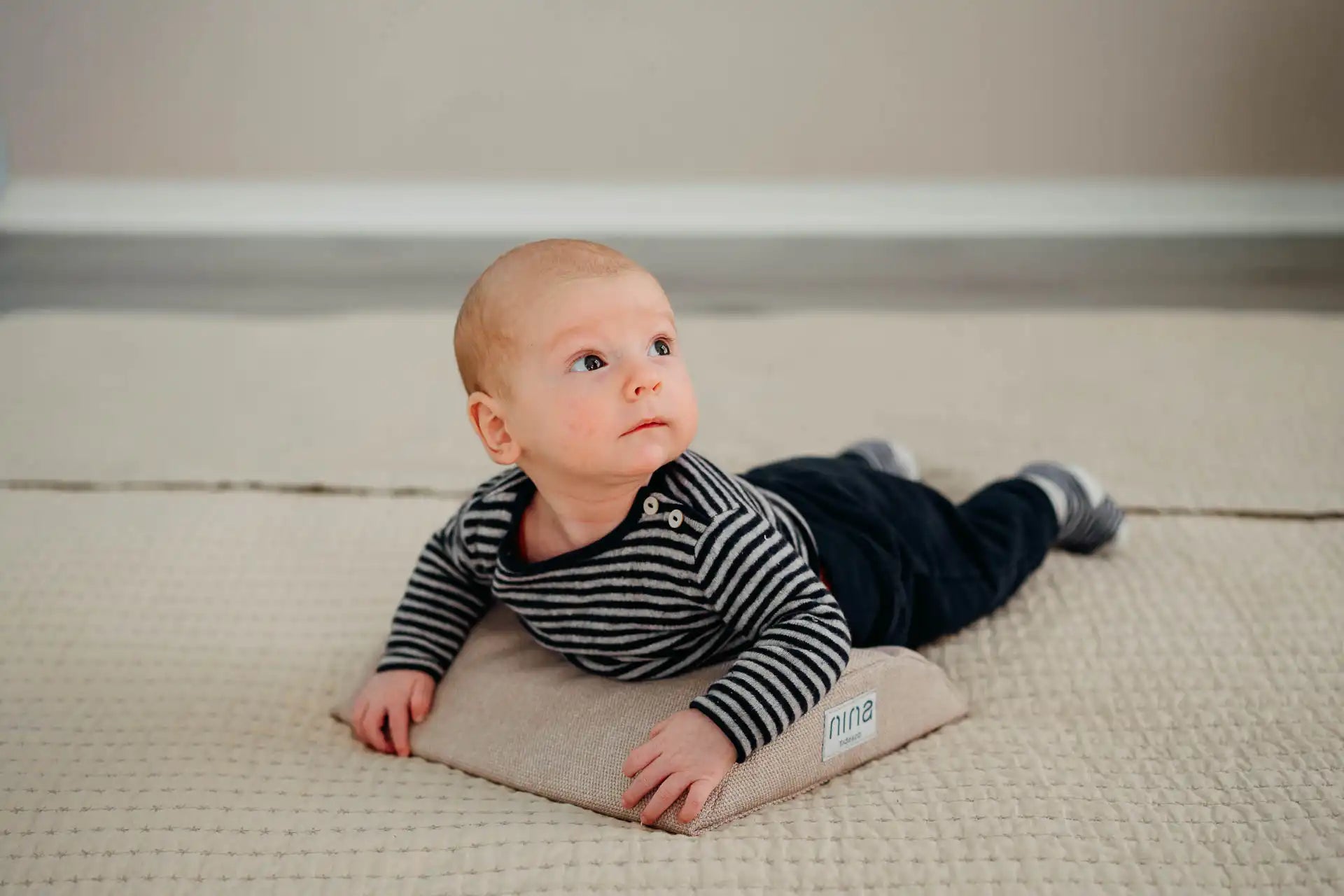 Baby in Bauchlage auf den Bauchissen